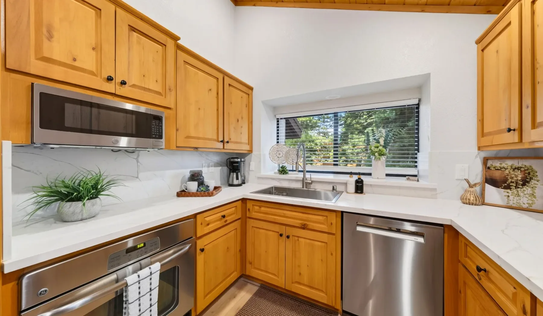 Una cocina con gabinetes de madera, encimera y electrodomésticos de acero inoxidable.