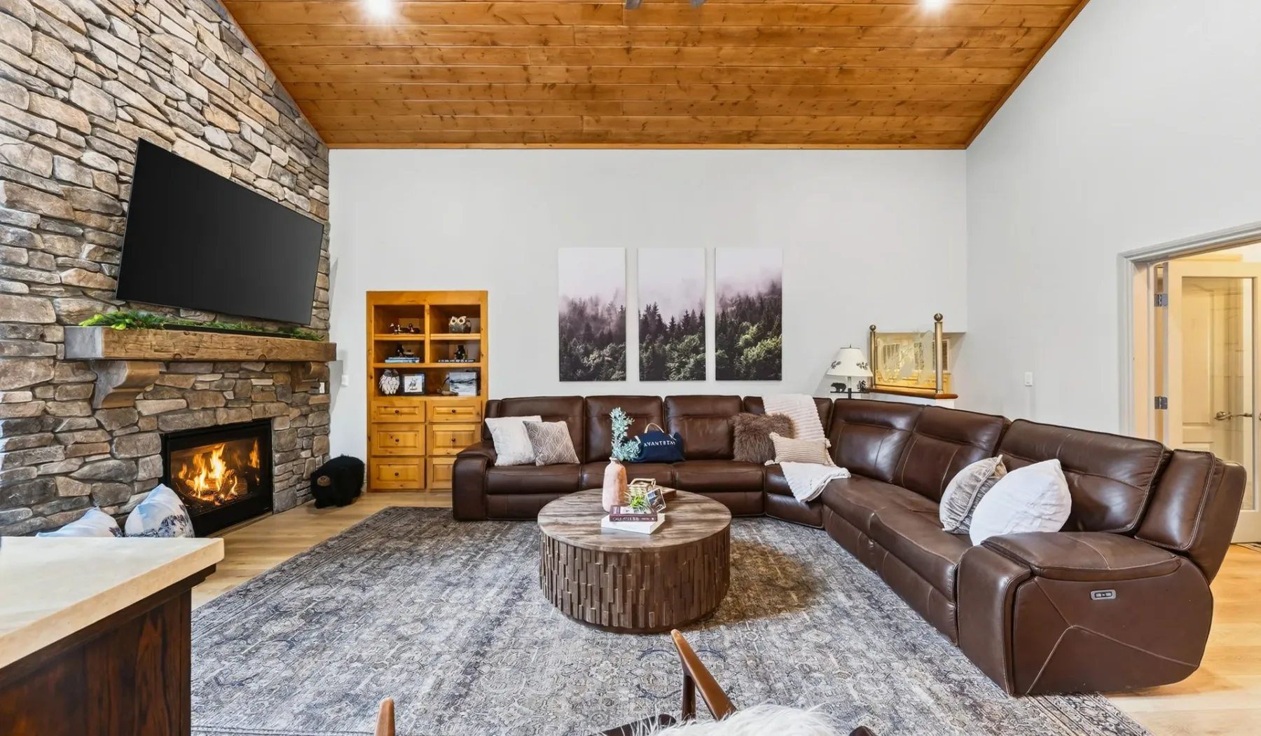 Una sala de estar con asientos de cuero alrededor de una mesa de centro y una chimenea.