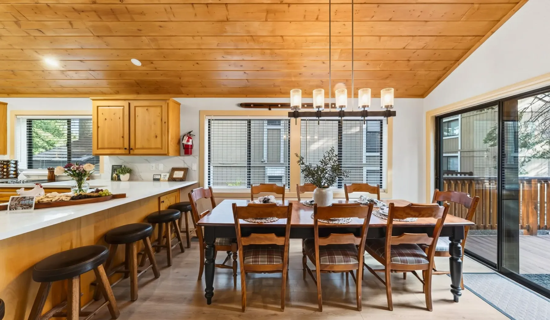 Un comedor con una larga mesa de madera bajo un techo revestido de madera.