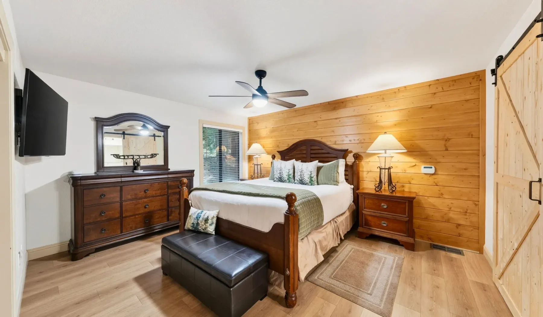 Un dormitorio con una cama de madera, mesitas de noche y una cómoda.