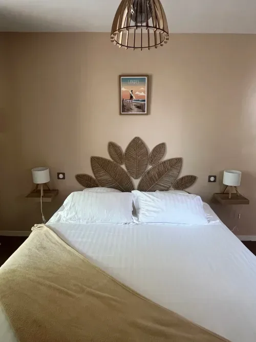 Habitación moderna con cabecero de hojas tejidas, ropa de cama blanca y decoración de pared con vistas al lago.