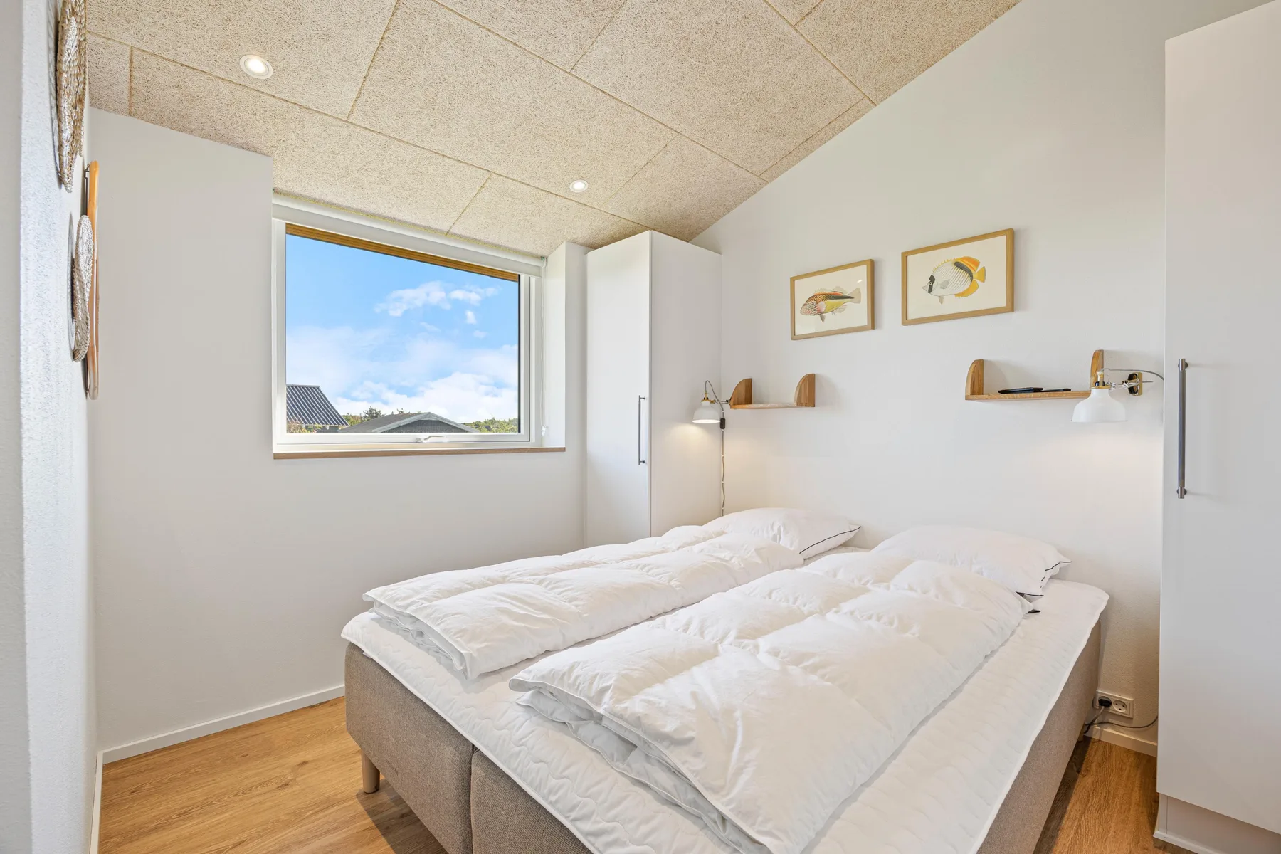 Un dormitorio con una cama doble bajo una ventana con vistas al cielo.