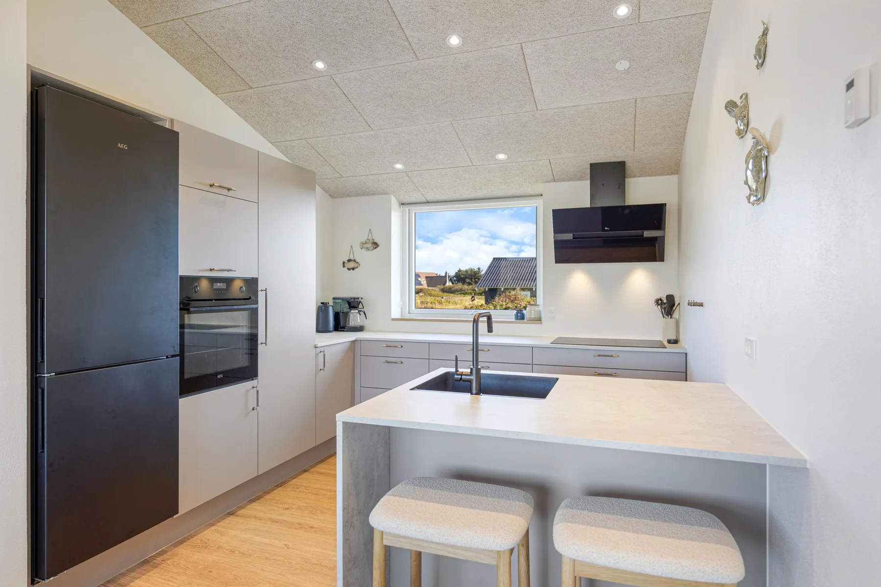 Una cocina moderna con una isla central y una ventana con vistas al exterior.