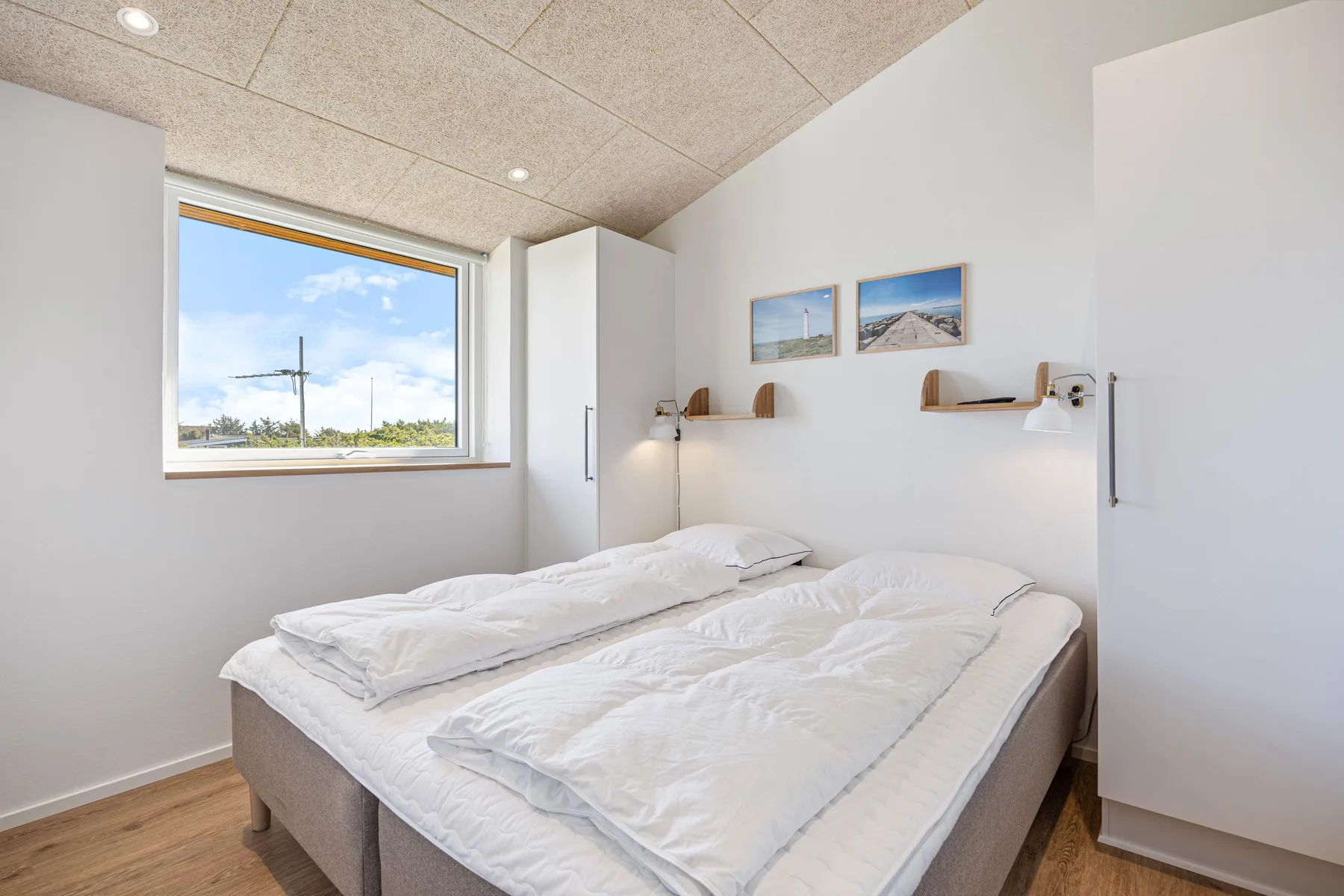 Un dormitorio con dos camas y una ventana grande.