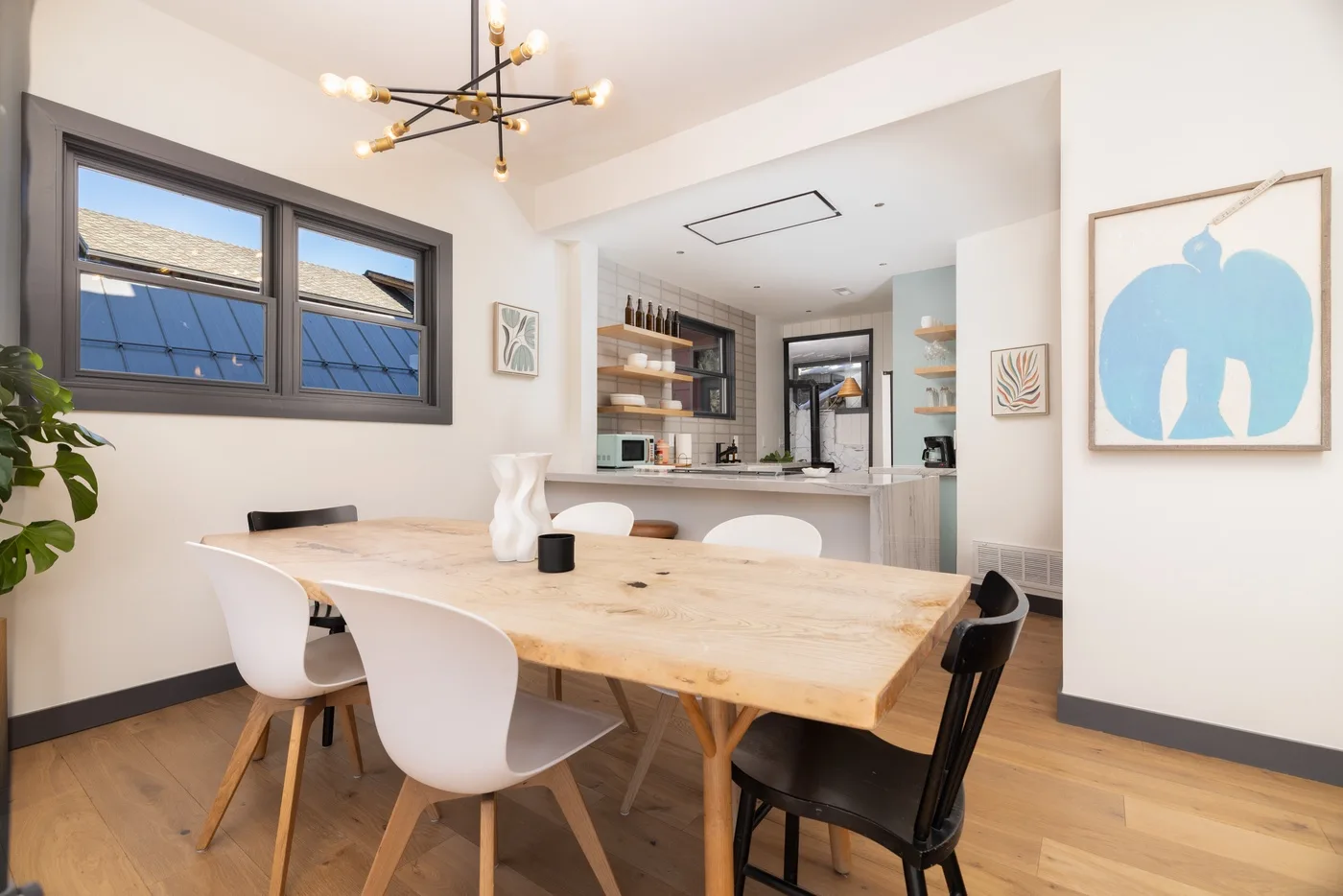 Comedor con una mesa de madera y una cocina abierta al fondo.