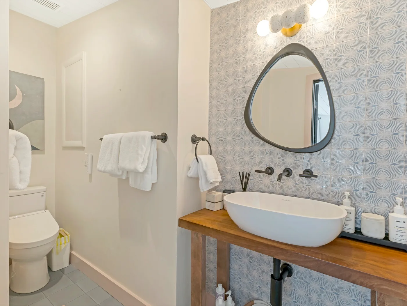 Un baño con una bañera, un espejo de pared y toallas.