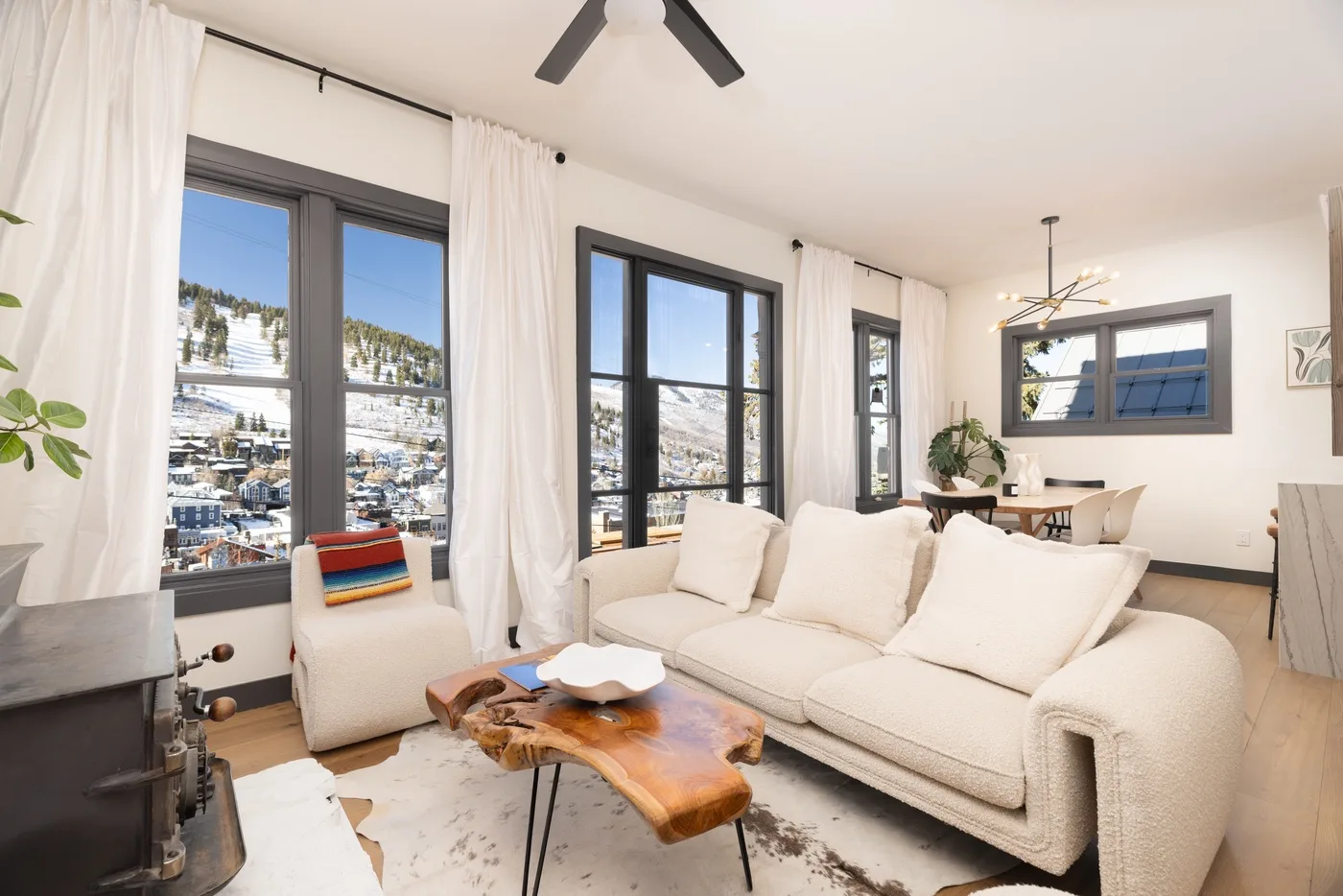 A bright living room with large windows and a white sofa.