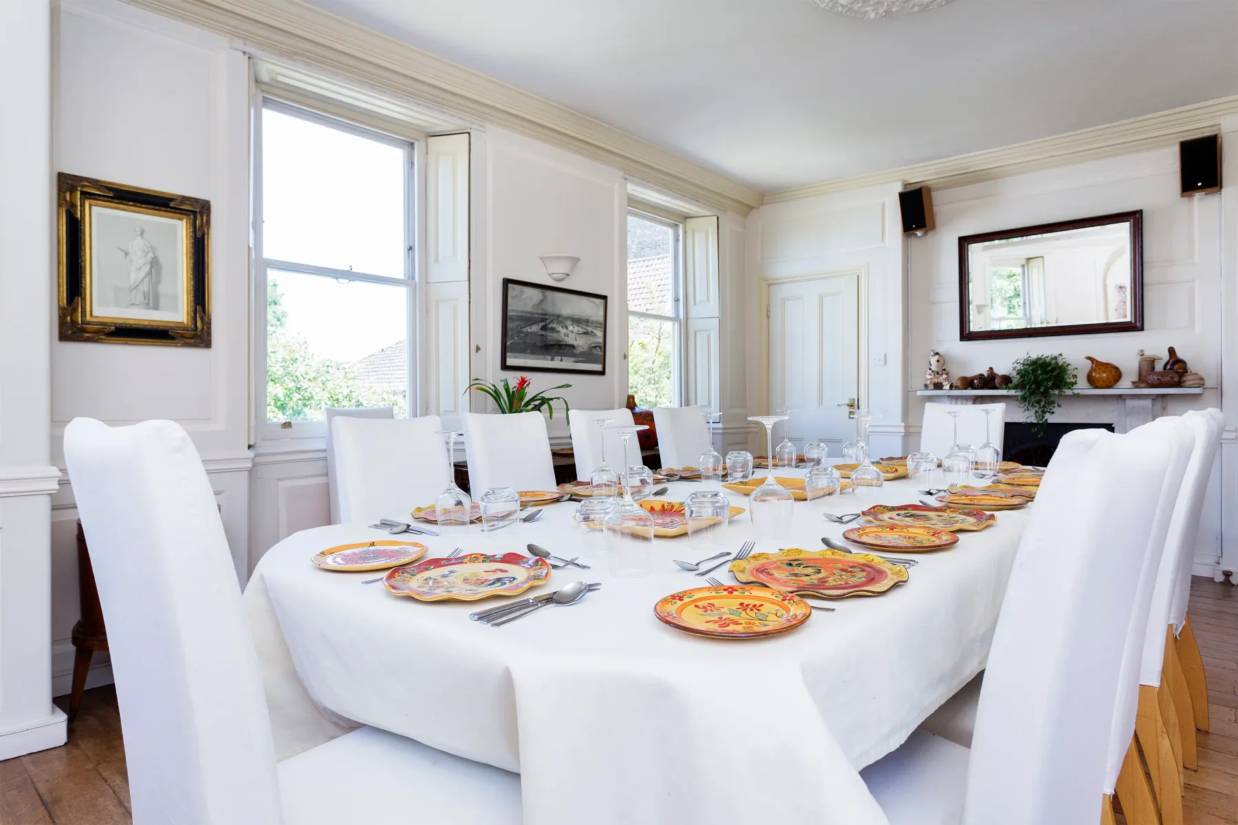 Un comedor con una mesa larga preparada con platos y comida.