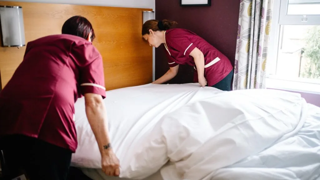 Hotel housekeeping team making a bed