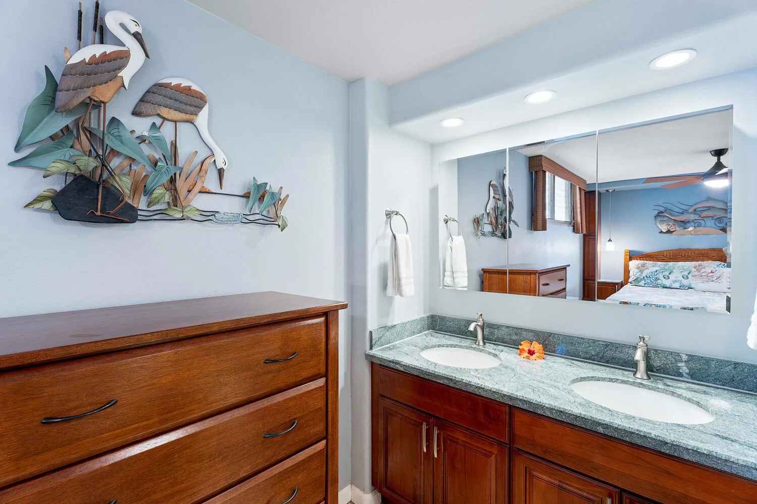 Tocador de baño con dos lavabos y un gran espejo de pared.