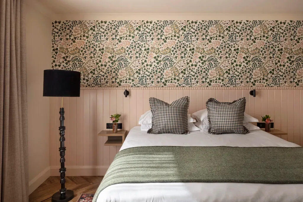 Habitación de hotel con una cama king size y una pared decorativa floral.