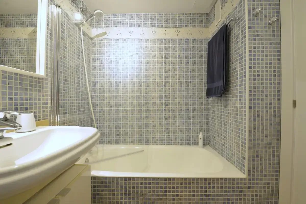 A tiled bathroom with a bathtub and sink.