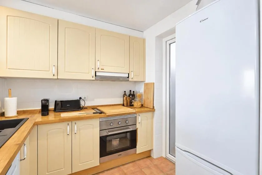 A compact kitchen with light-colored cabinets, a countertop, and a built-in oven.