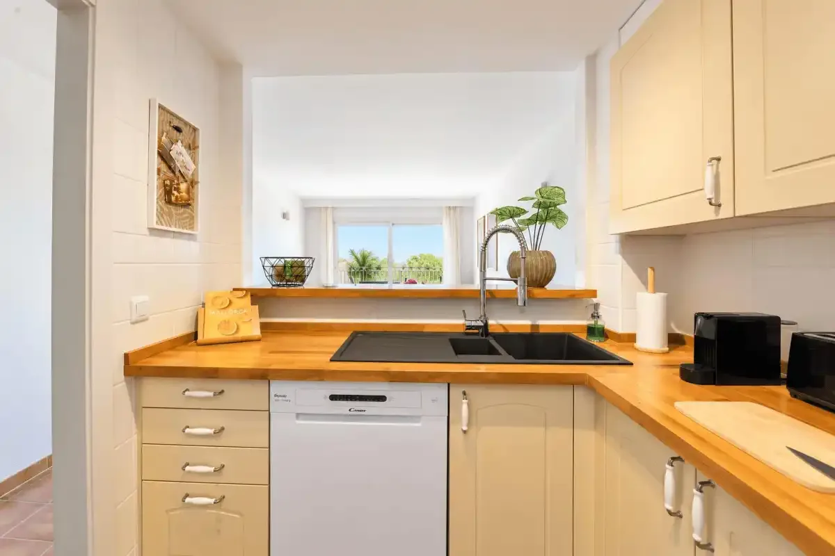 A bright kitchen with wooden countertops and a window above the sink.