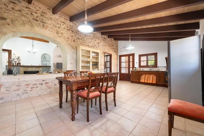 A dining area with a wooden table and seating beside a stone archway.