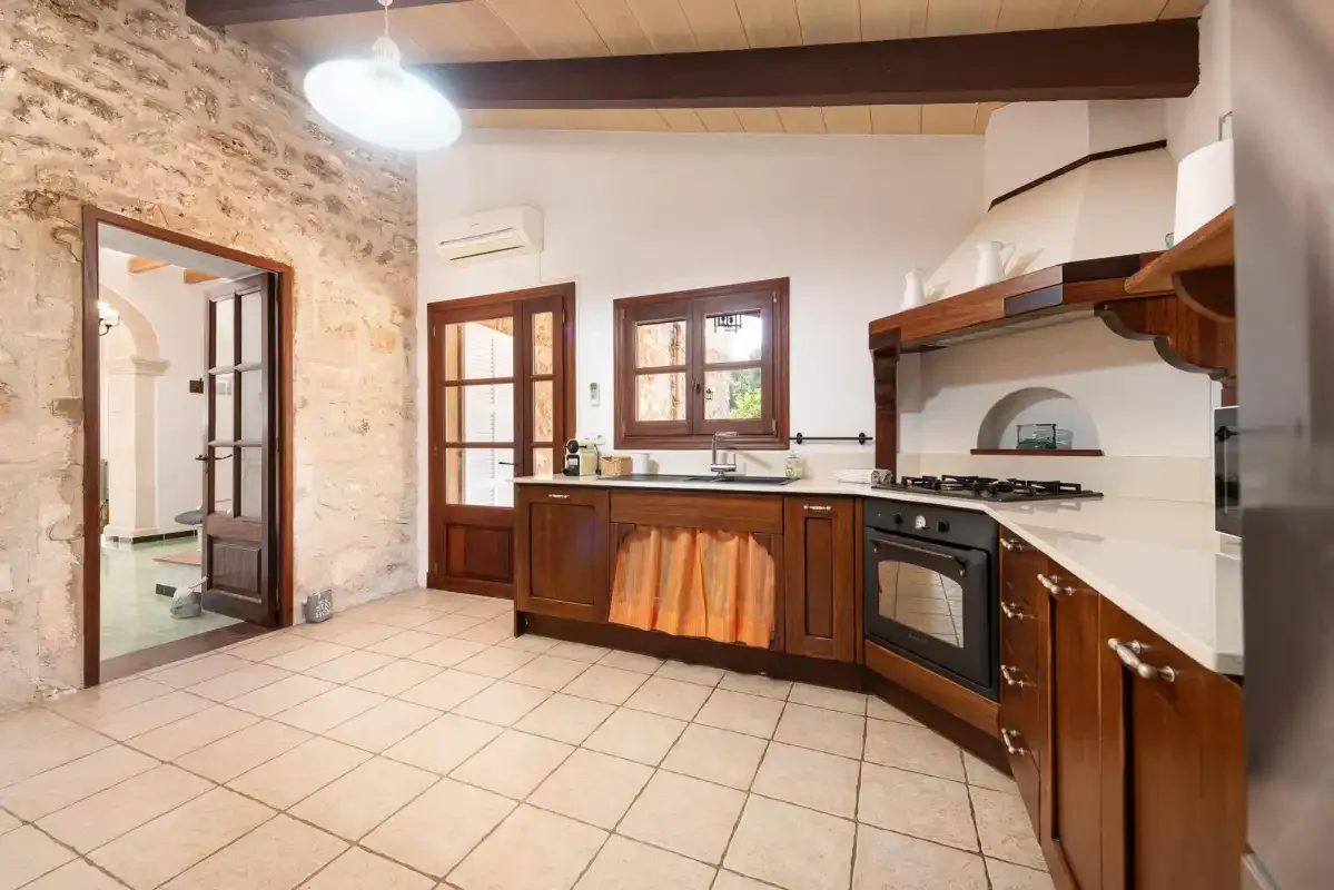 A kitchen with wooden cabinets, a countertop, and a tiled floor.