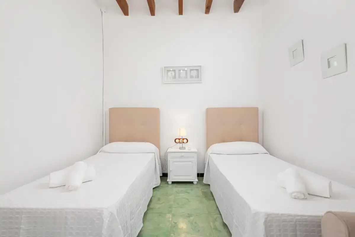 A bedroom with two single beds and a small bedside table between them.