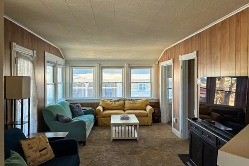 A living room with seating, a coffee table, and a television.