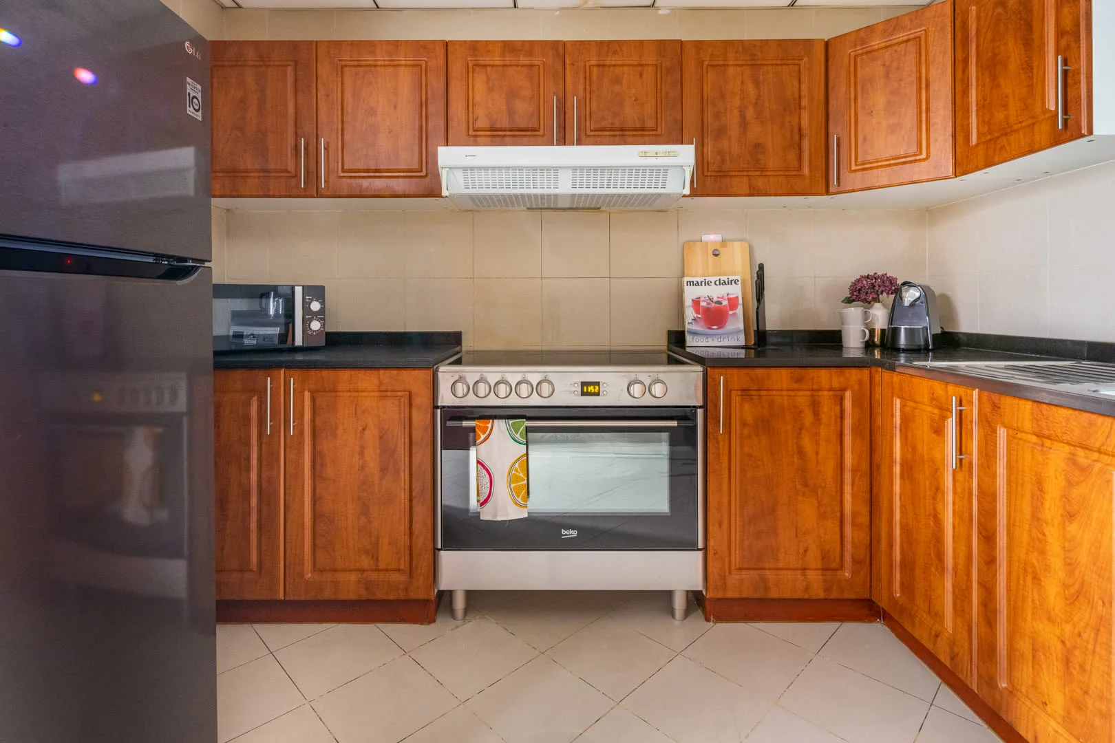 Una cocina con gabinetes de madera, una estufa y un refrigerador.