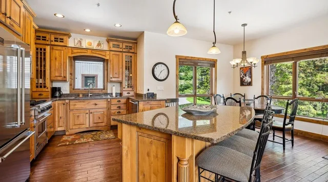 Una cocina amplia con una isla grande y una mesa de comedor junto a las ventanas.
