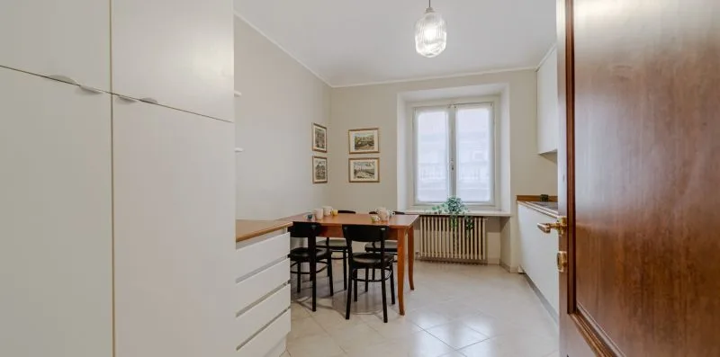 Una cocina con una mesa y sillas junto a una ventana.