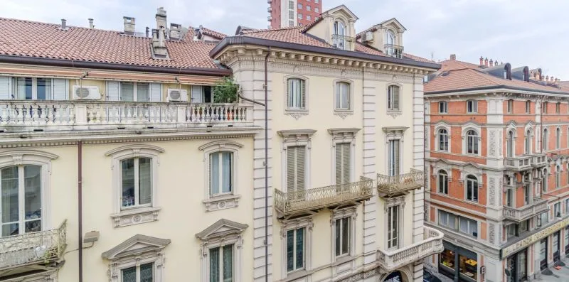 Una calle urbana con edificios históricos, hileras de ventanas y balcones.