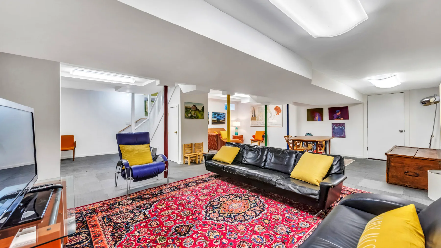 A lounge with a black sofa and colorful patterned rug.