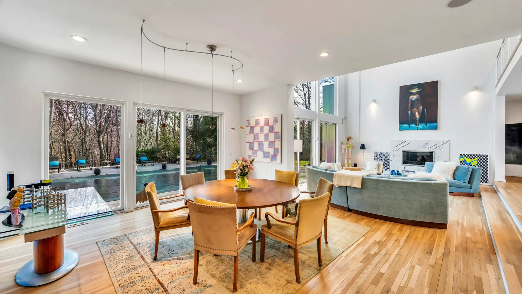 A bright open-plan living and dining room with a wooden dining table and seating.