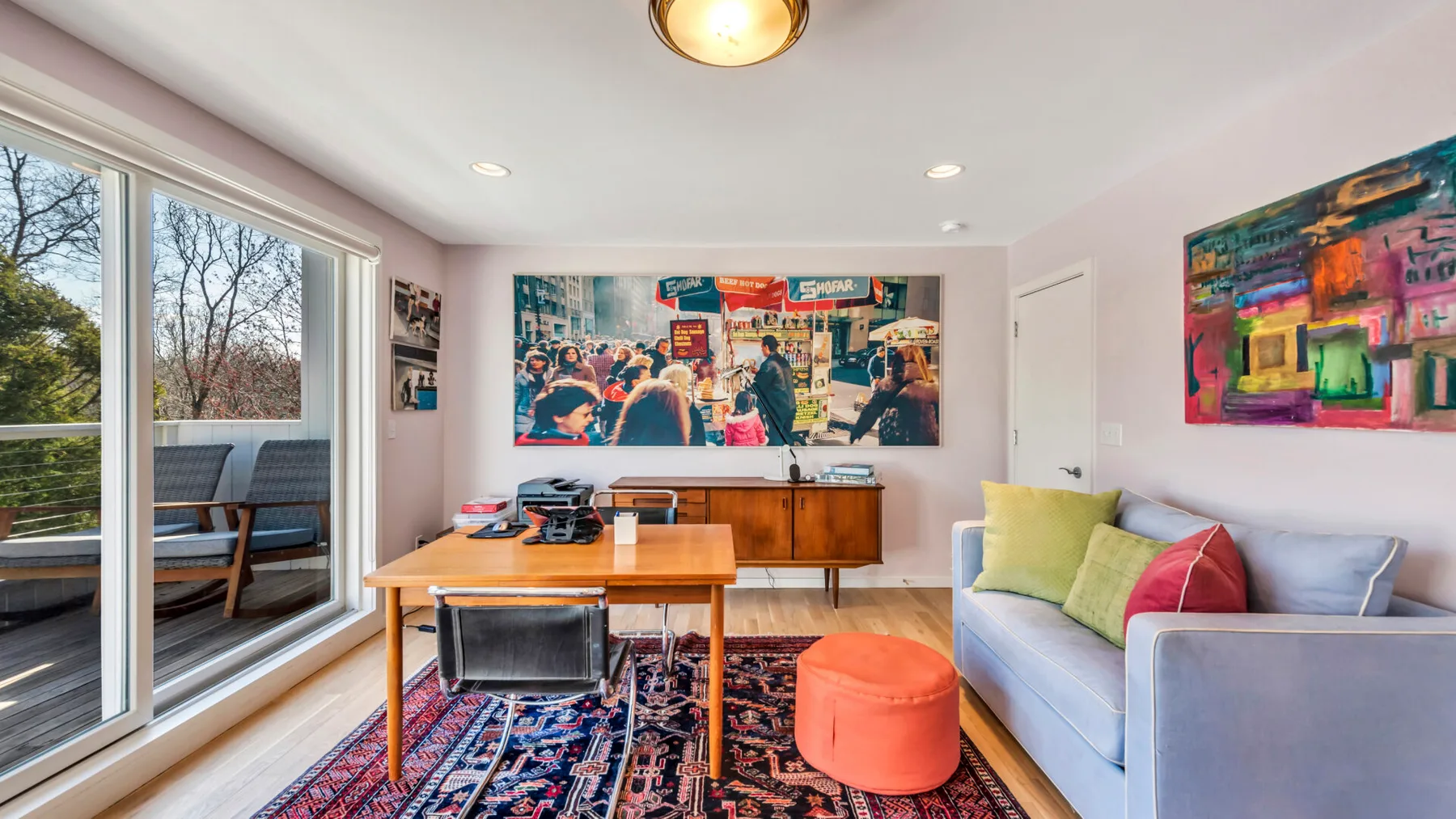 A bright living room with a sofa, coffee table, and colorful wall art.