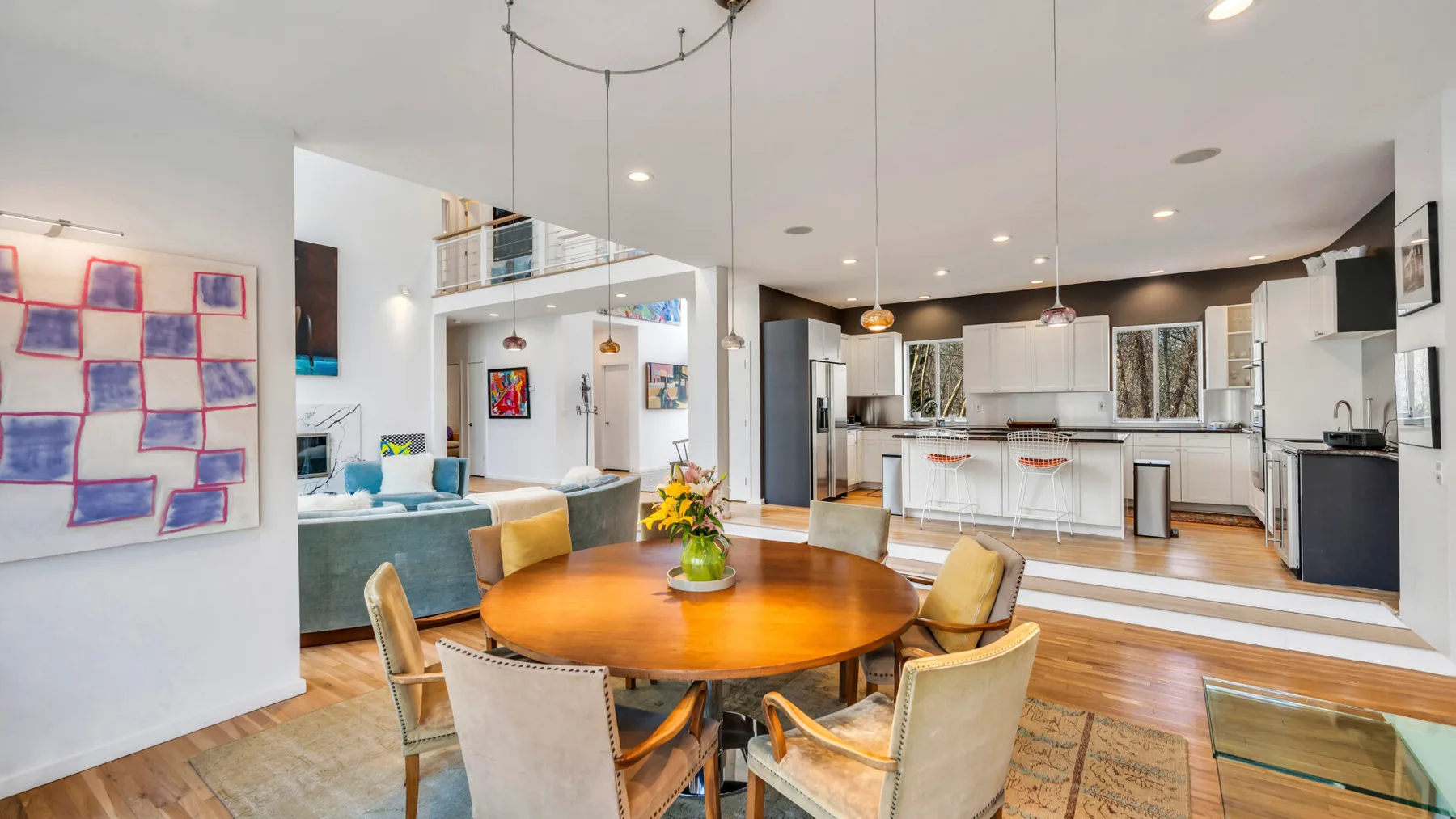 An open-plan living and dining area with a round table and kitchen.