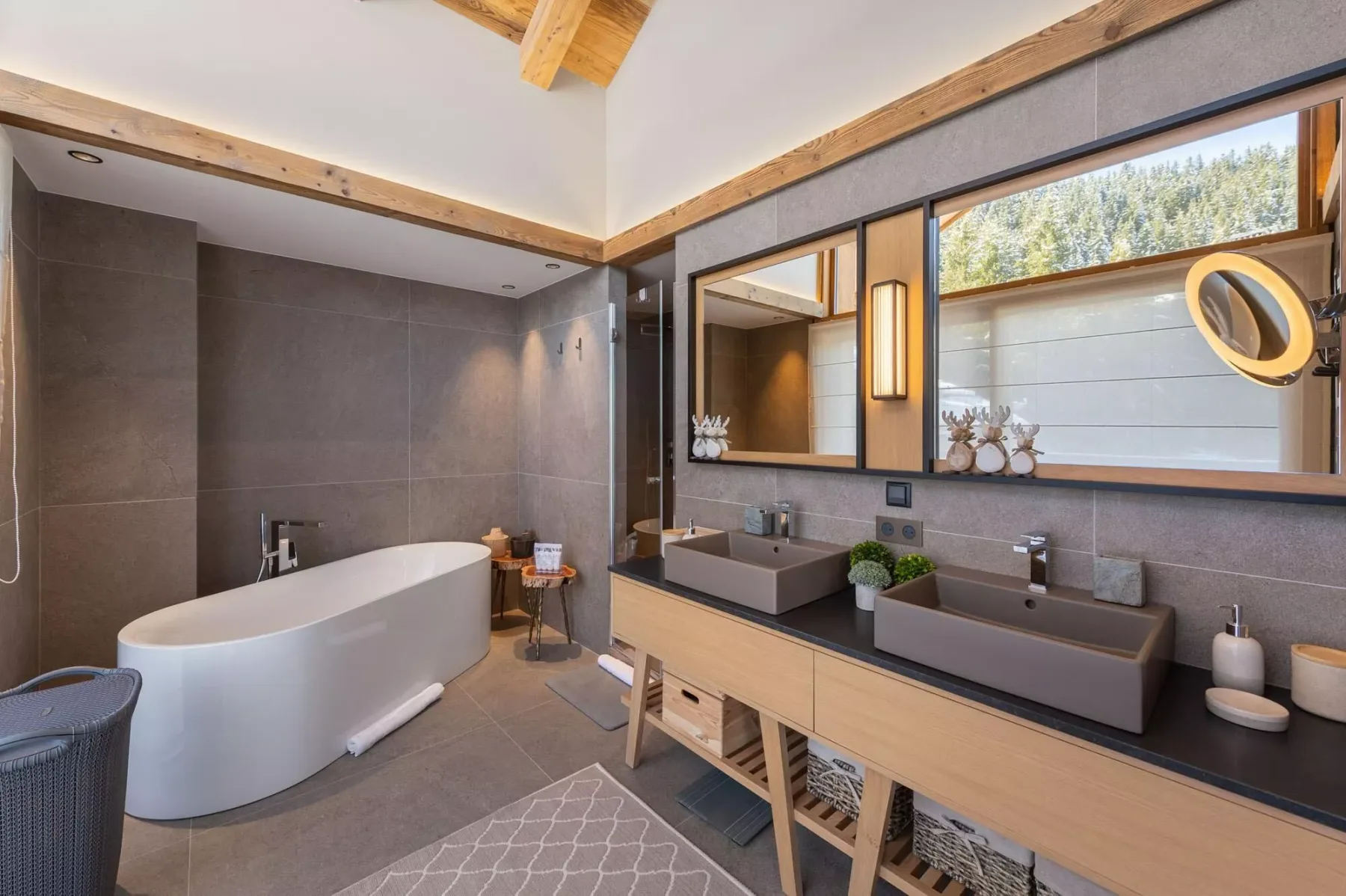 Un baño con bañera exenta, dos lavabos y un espejo grande.