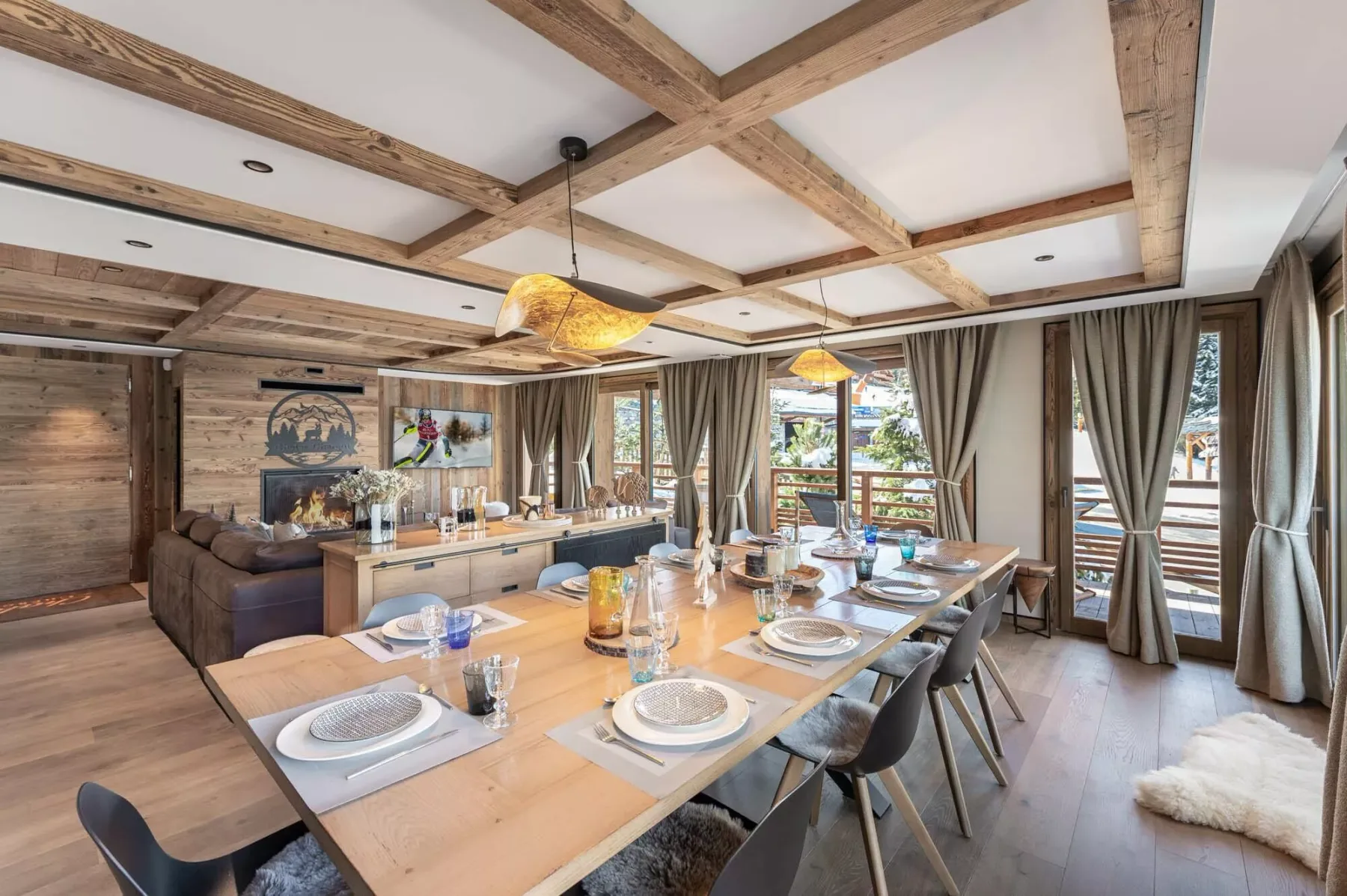 Un comedor con una mesa larga puesta con platos y vigas de madera a la vista.