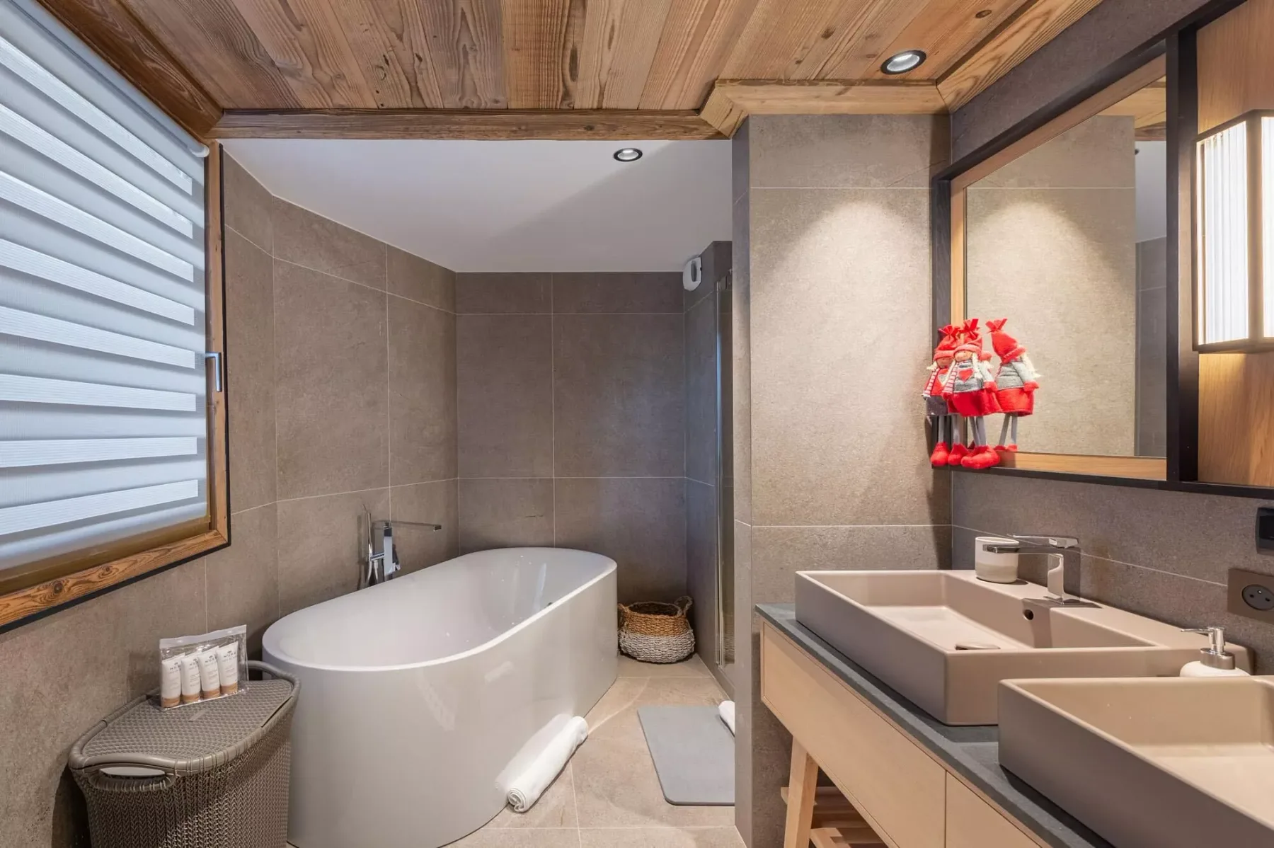 Un baño con azulejos, bañera y un lavabo doble.