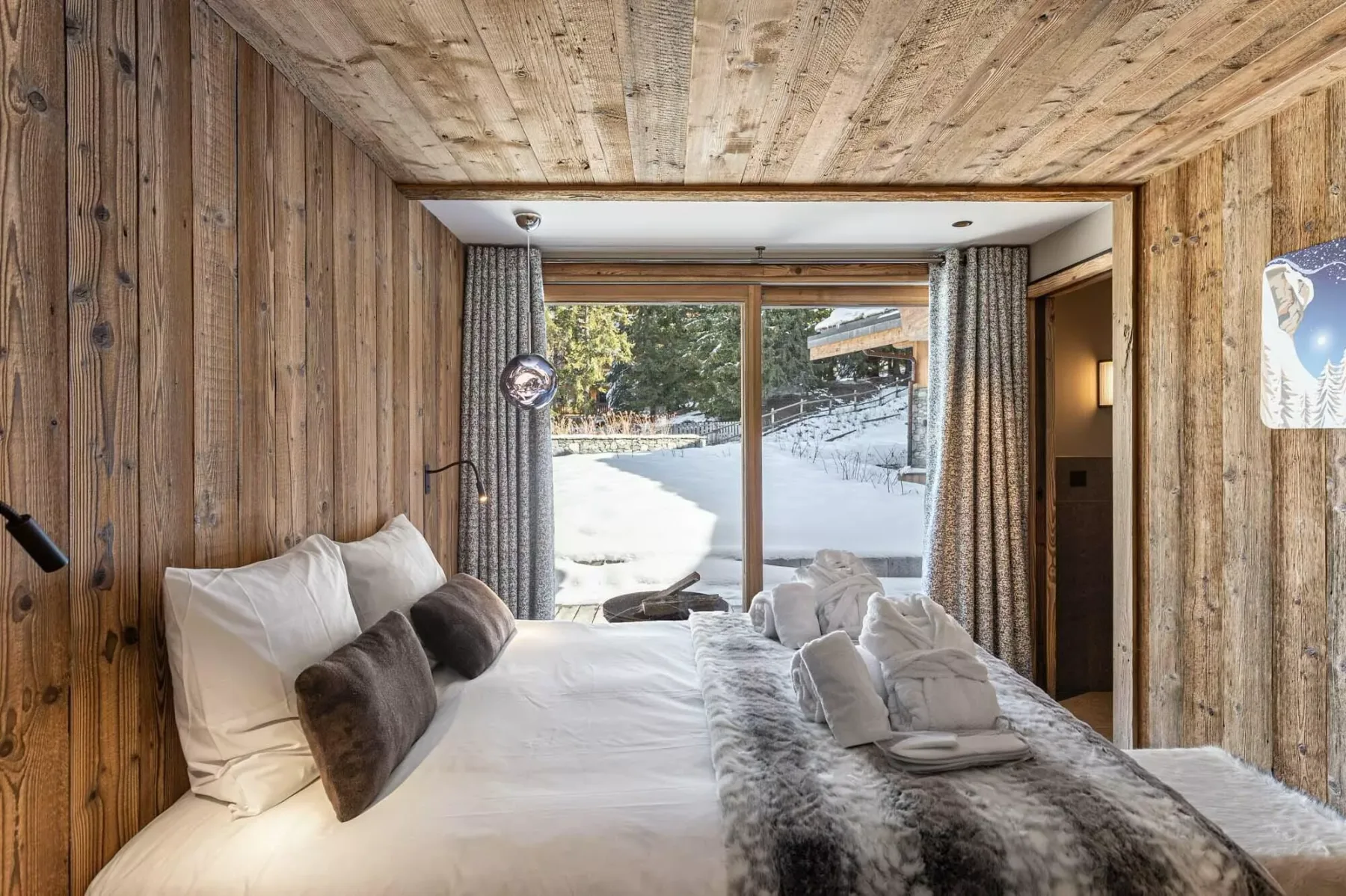 Un dormitorio con una gran ventana que da a un paisaje nevado.