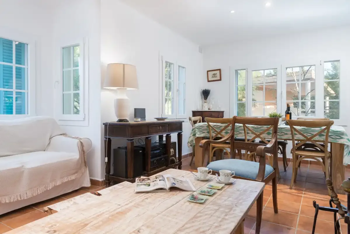 Una luminosa sala de estar y comedor con asientos alrededor de una mesa de madera.