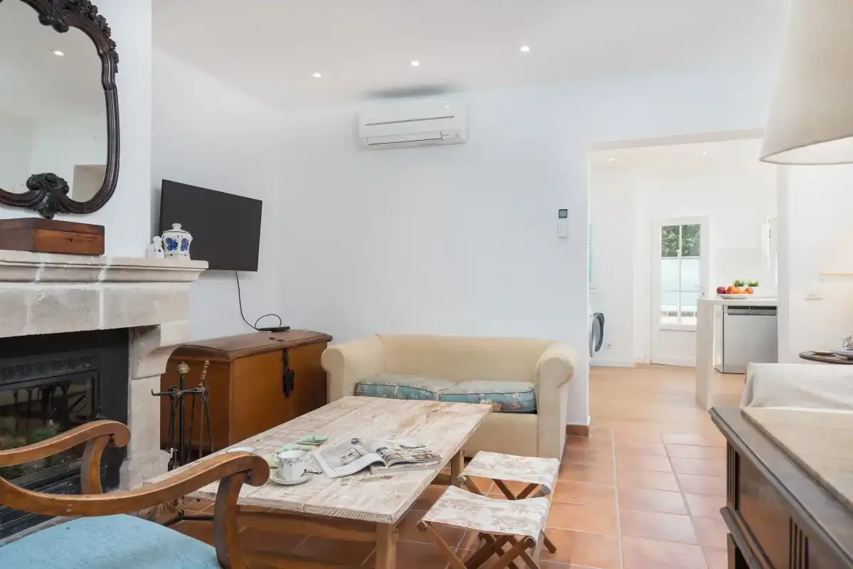 Una sala de estar luminosa con asientos, una chimenea y un televisor.