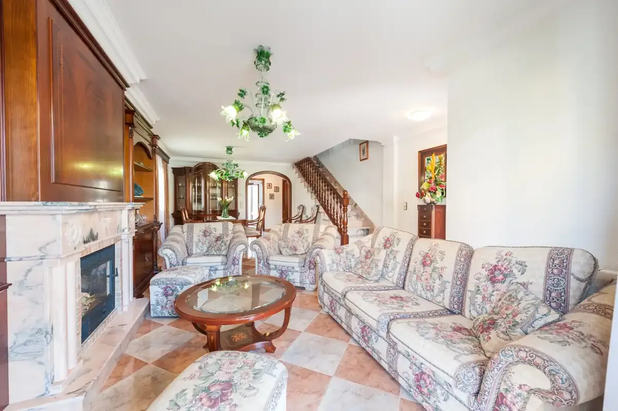 A living room with patterned seating, a coffee table, and a fireplace.