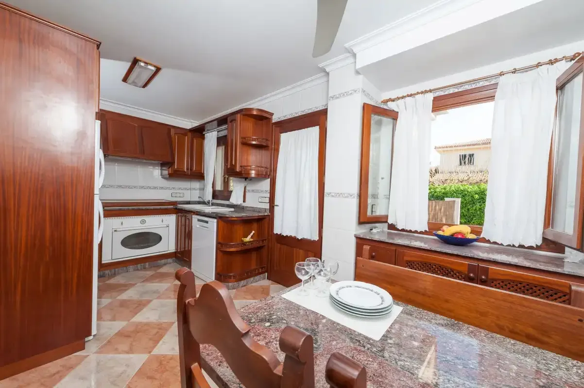 A kitchen and dining area with wooden cabinets and a table set with dishes.
