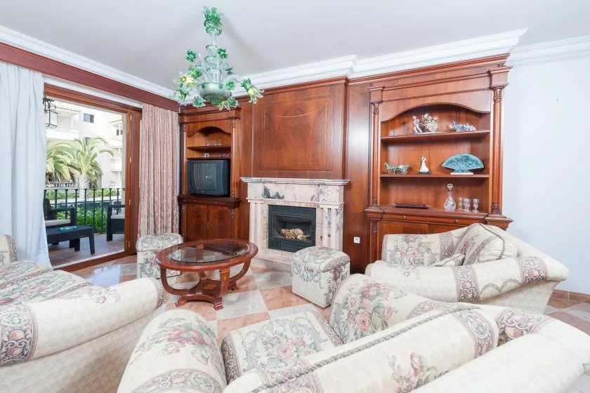 A living room with upholstered seating, a fireplace, and wooden display cabinets.