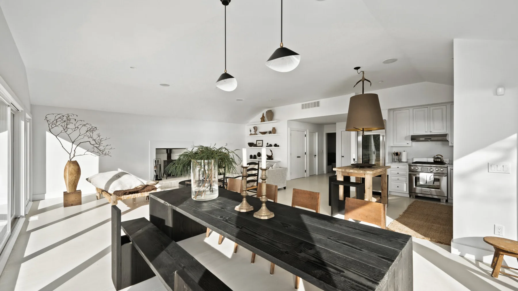 Una luminosa cocina-comedor de planta abierta con una mesa larga y oscura.