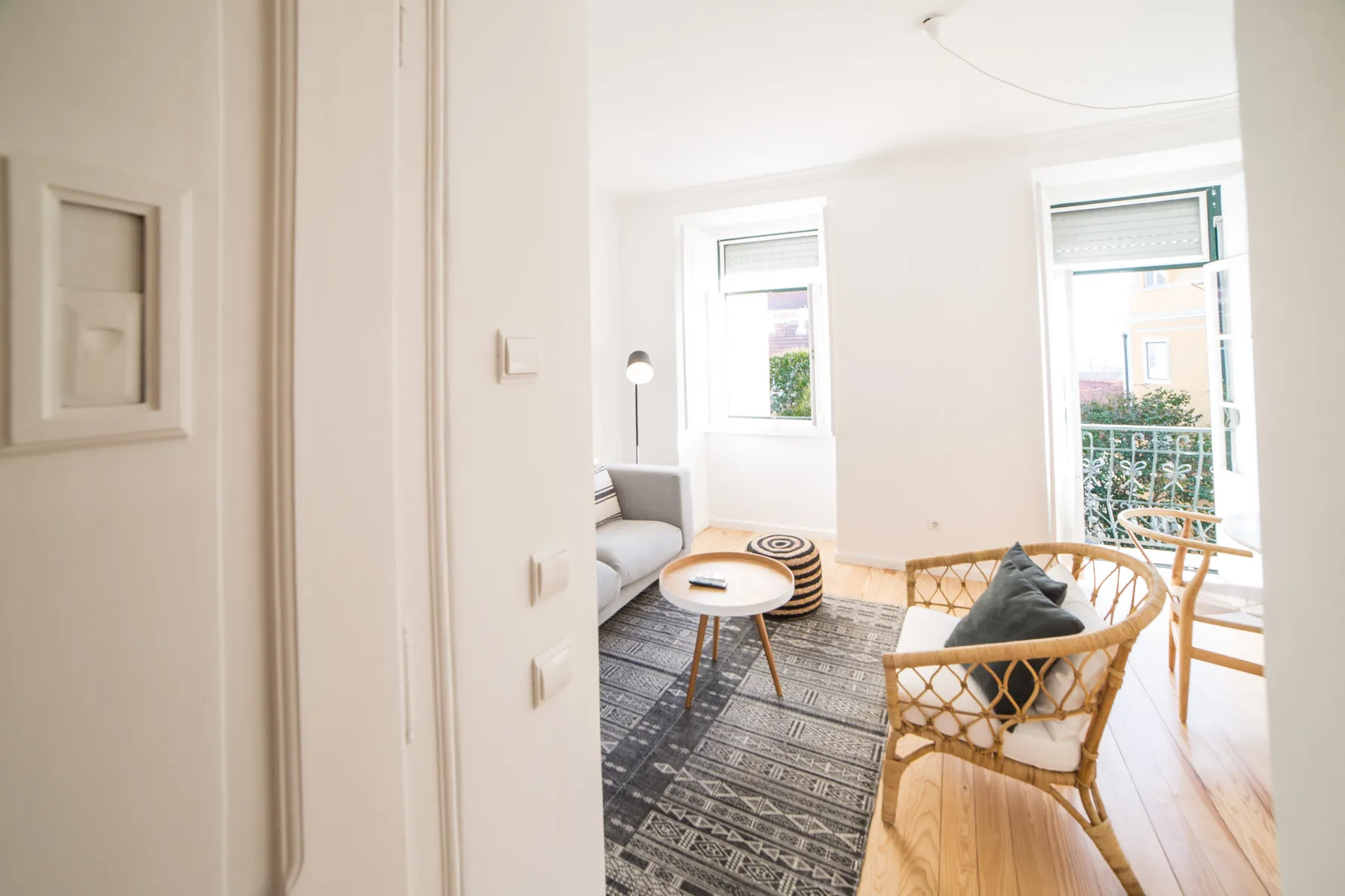 A bright living room with a seating area, coffee table, and windows.