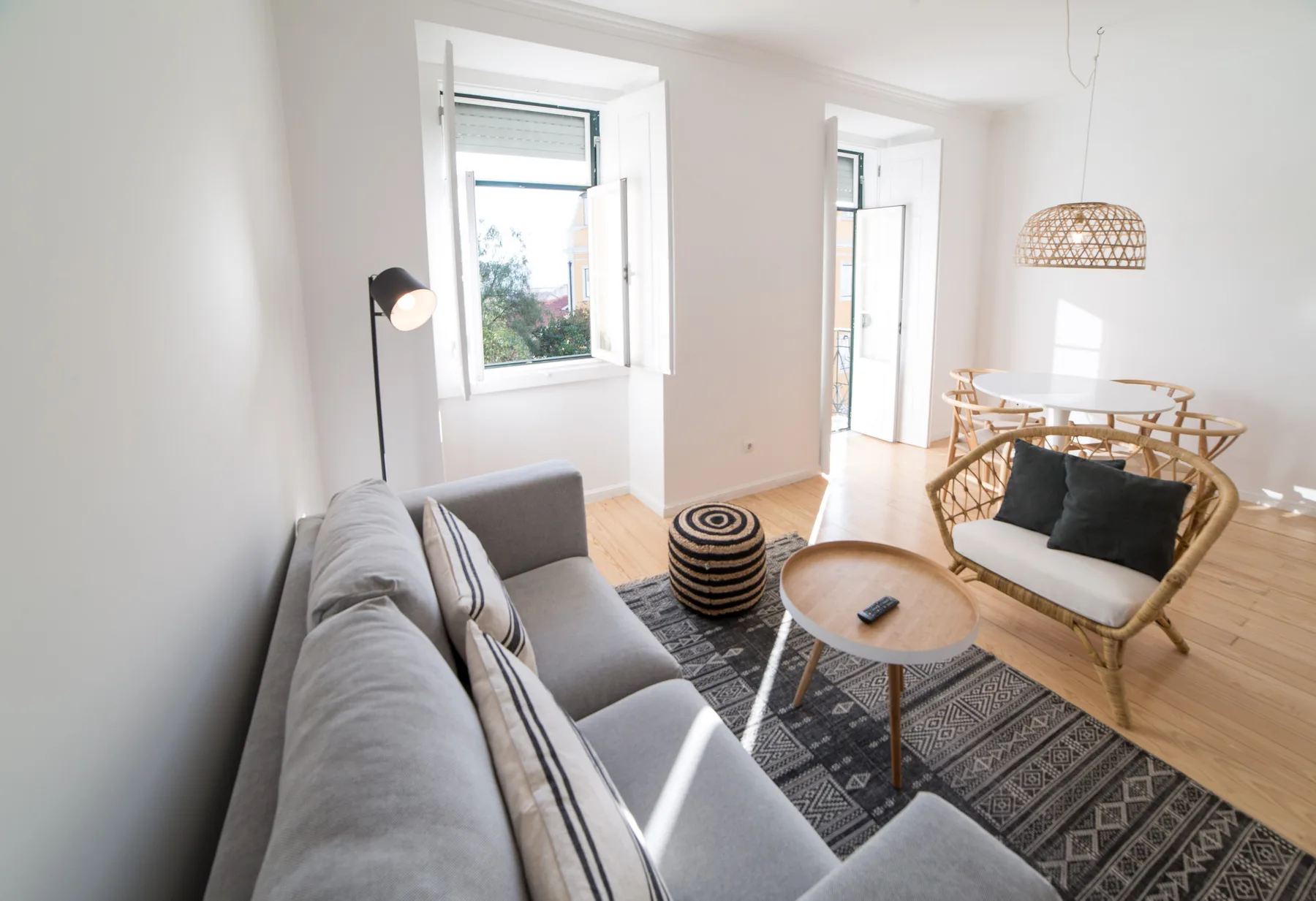 A bright living room with seating, a round table, and large windows.