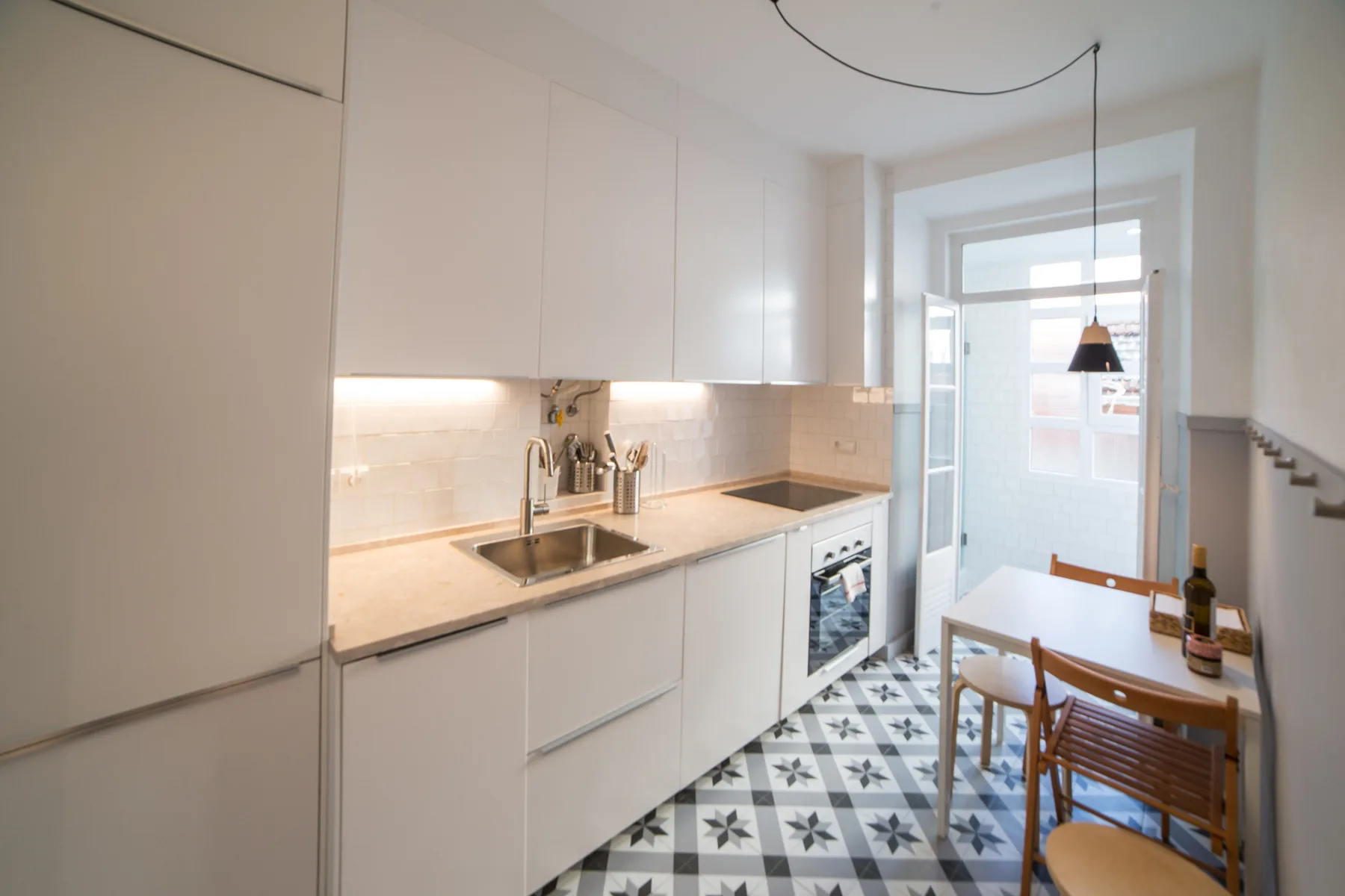 A bright kitchen with a dining table beside the windows.