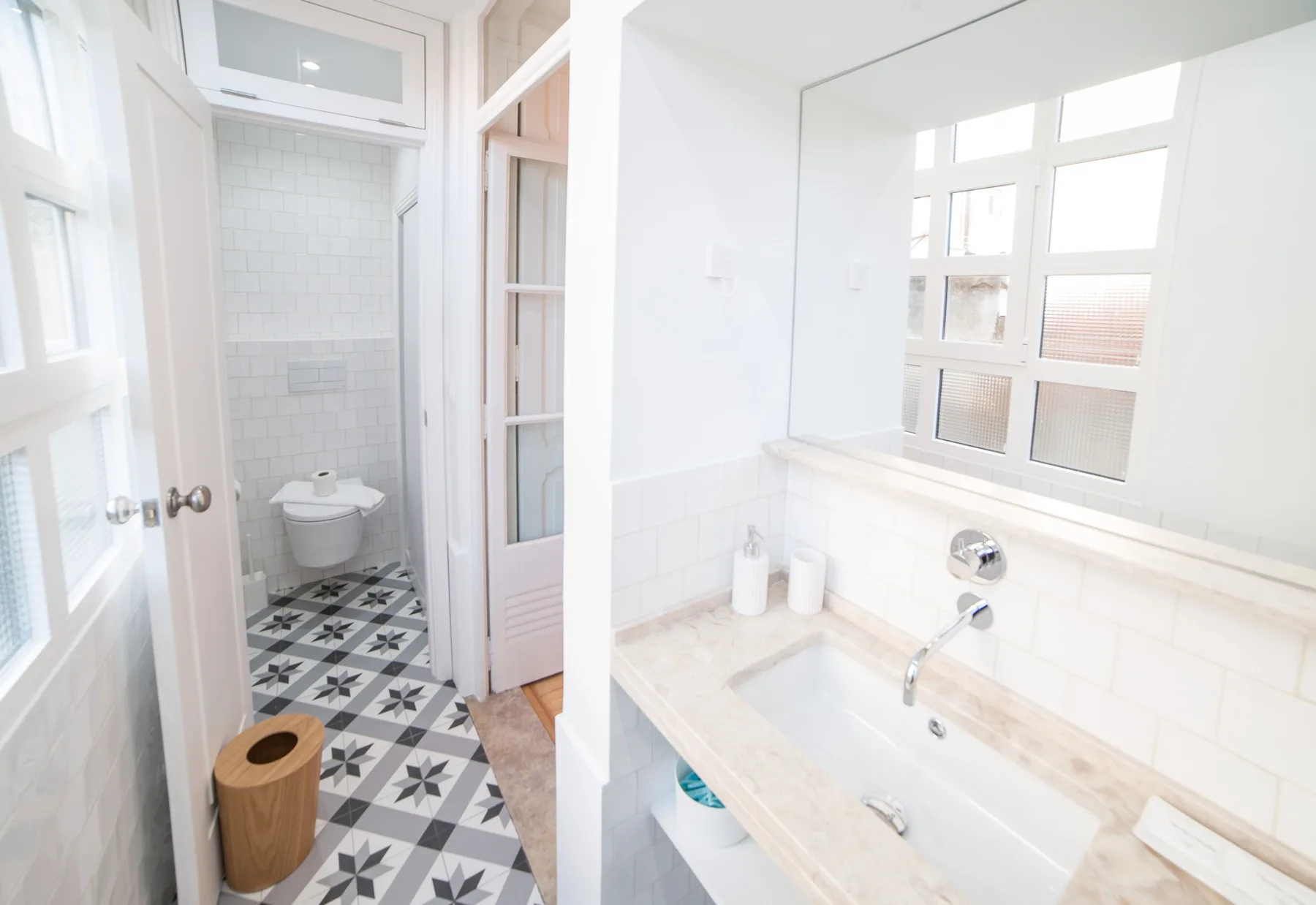A bright bathroom with a bathtub, sink, and tiled shower area.