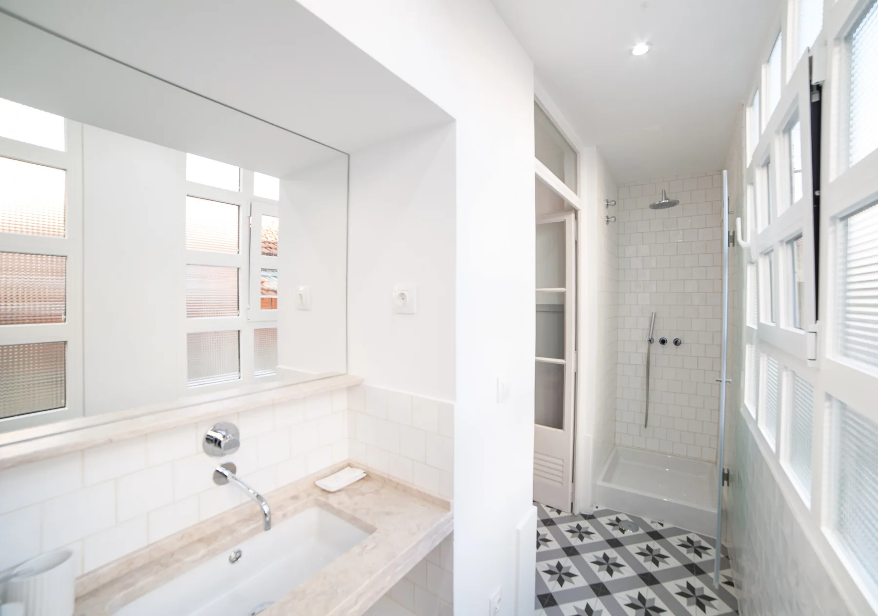 A bright bathroom with a bathtub, sink, and tiled shower area.