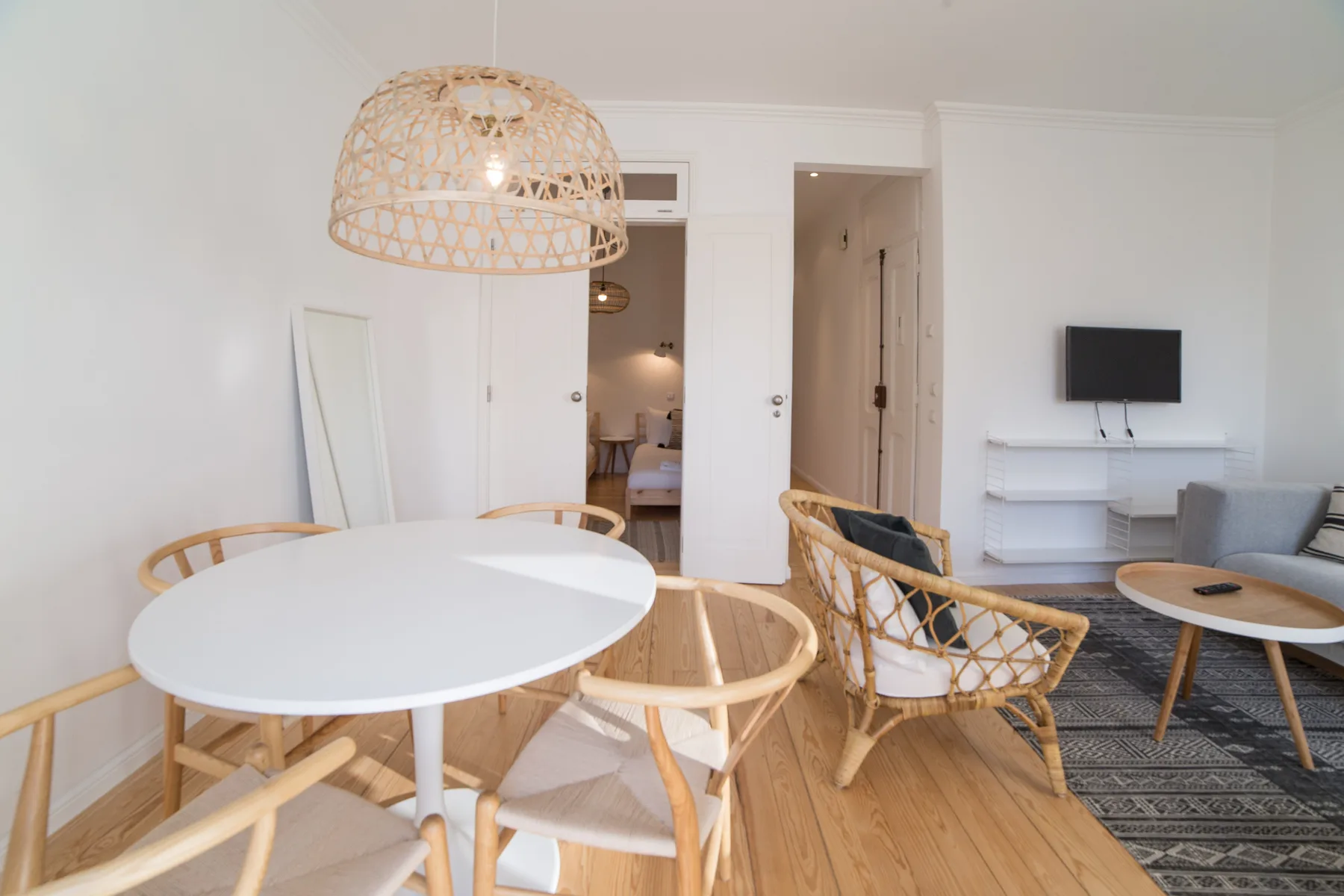 A bright living and dining area with a round table and seating.