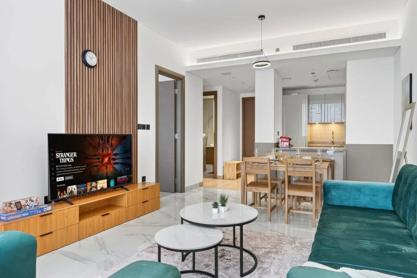 Una luminosa sala de estar y comedor con televisión, asientos y una mesa.