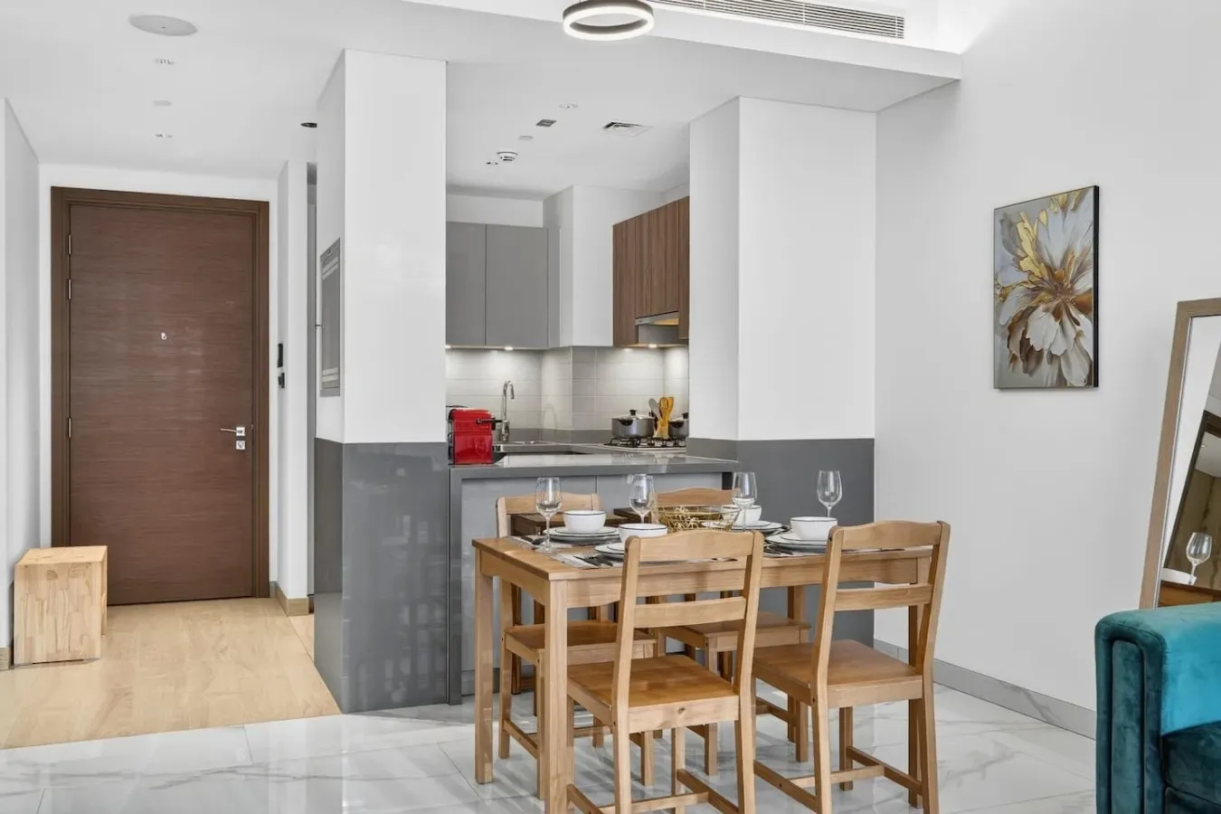 Comedor con mesa y sillas de madera junto a una cocina abierta.
