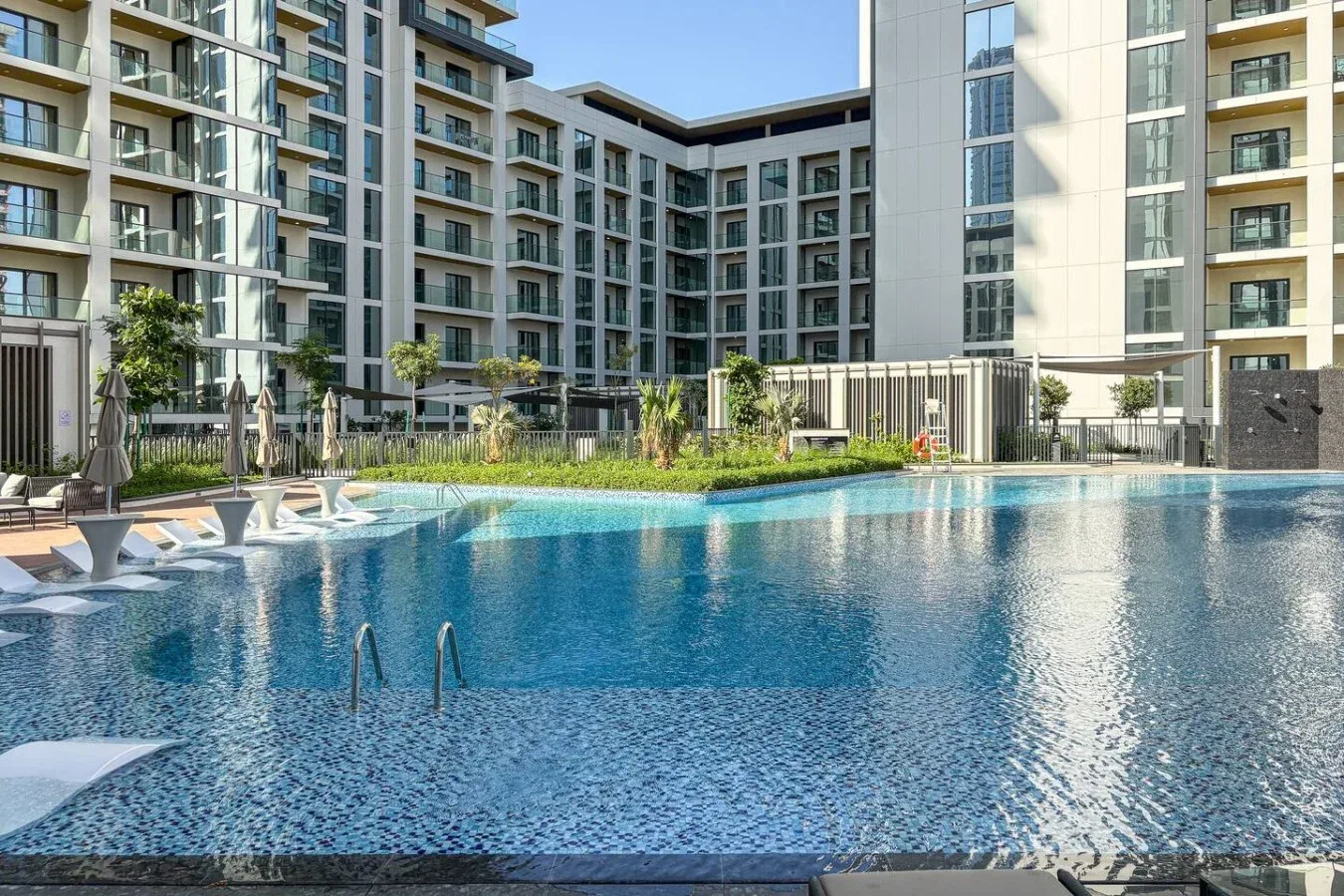 Una piscina está en el patio de un moderno edificio de apartamentos.