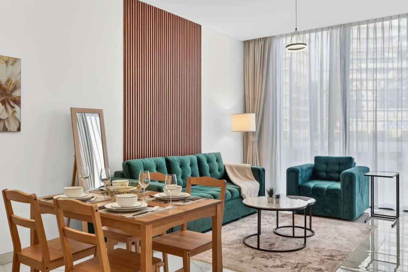 Una luminosa sala de estar y comedor con asientos color turquesa y una mesa de madera.
